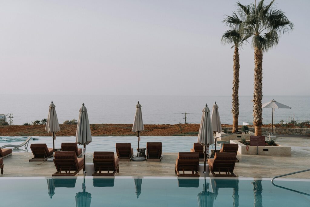 a pool with chairs and umbrellas by the water Marriott Bonvoy