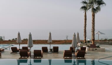 a pool with chairs and umbrellas by the water Marriott Bonvoy