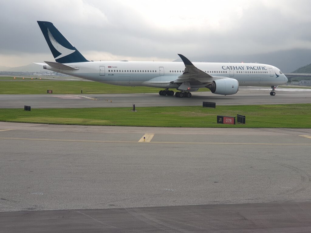 a large white airplane on a runway Cathay A350