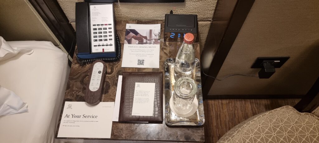 a table with a phone and a glass bottle on it