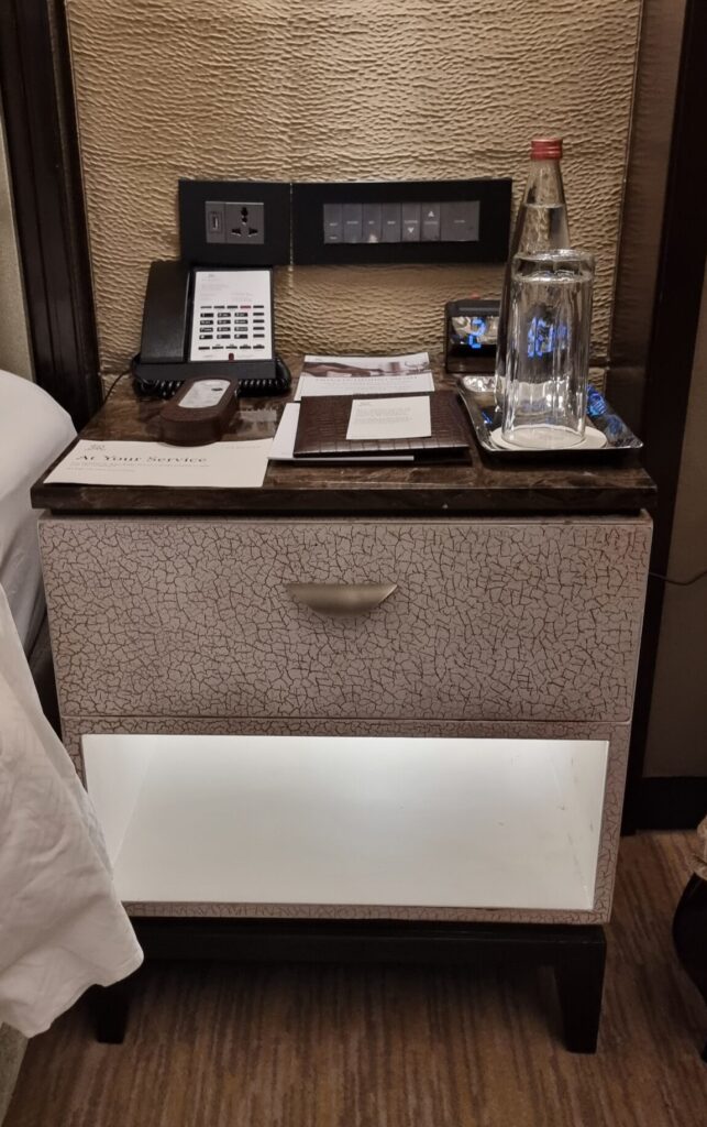 a nightstand with a phone and a telephone on it