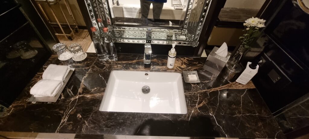 a sink with soap and bottles on a counter