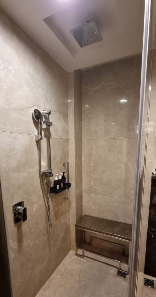 a shower with a bench and a shelf