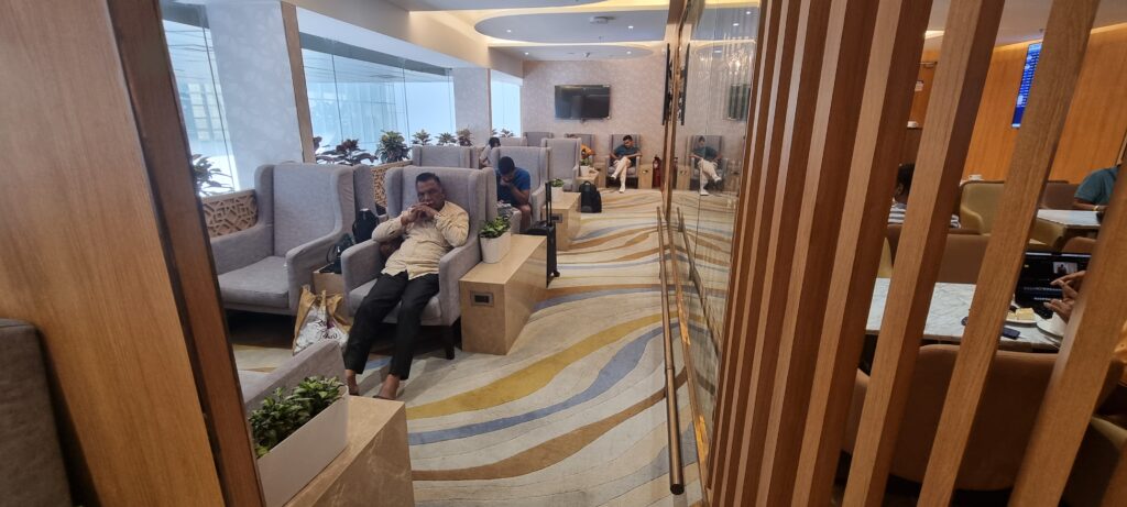 a man sitting in a chair Adani lounge Jaipur