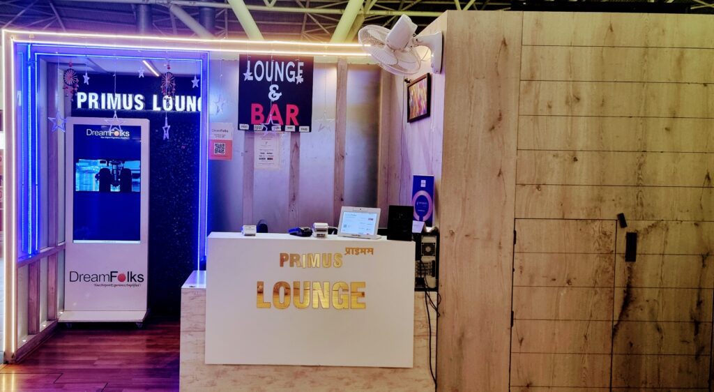 a white reception desk with a white hat and a sign Primus Lounge Amritsar