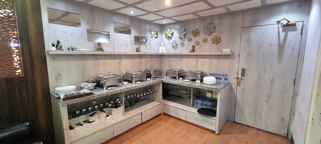 a buffet with silver trays and silver objects on shelves Primus lounge Amritsar