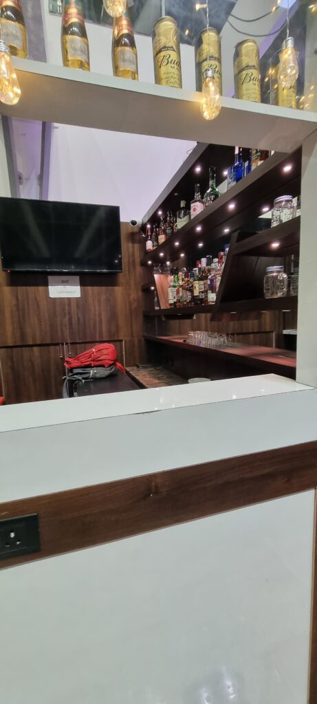 a bar with shelves of liquor and a television