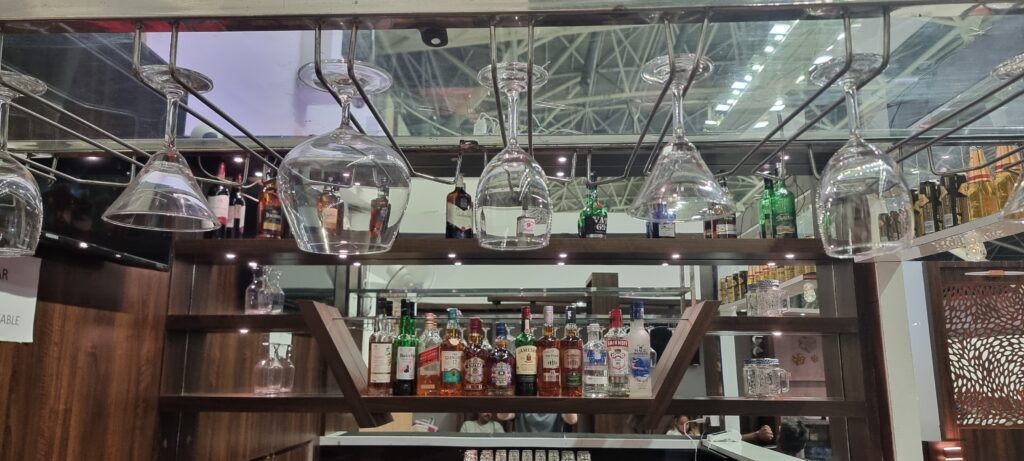 a shelf with wine glasses and bottles