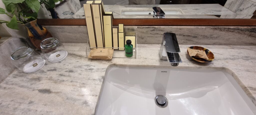 a sink with a faucet and a bottle of perfume on it