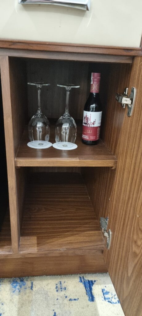 wine glasses and a bottle on a shelf