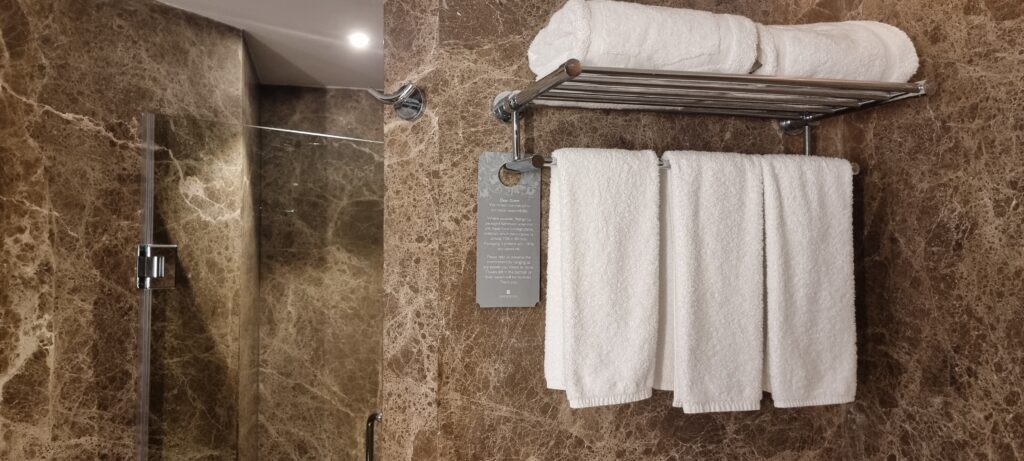a towel rack with a sign and towels on it