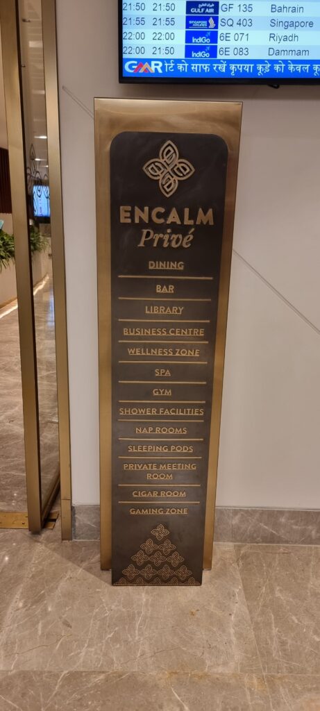 a sign with gold text on it lounge amenities in the Encalm Privé lounge Delhi