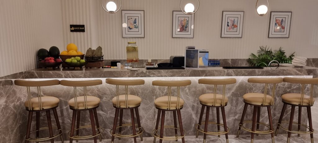 a bar with stools in front of a counter juice bar at Encalm Privé lounge Delhi