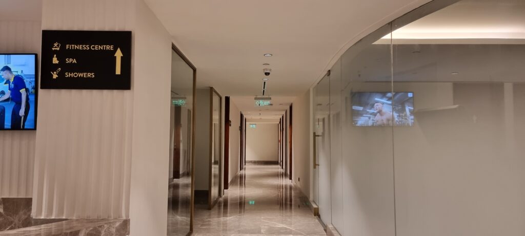 a hallway with a glass door gym and spa entrance at the Encalm Privé lounge Delhi