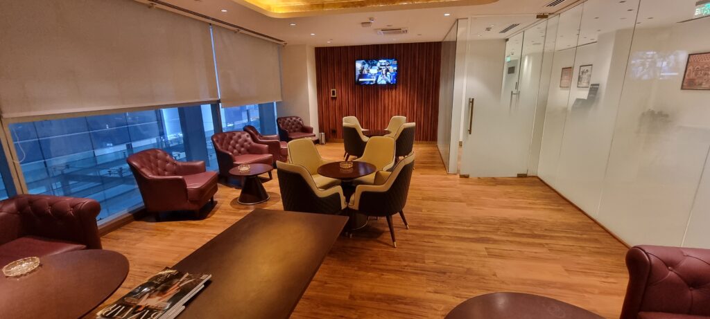 a room with chairs and a table smoking room in Encalm Privé lounge Delhi