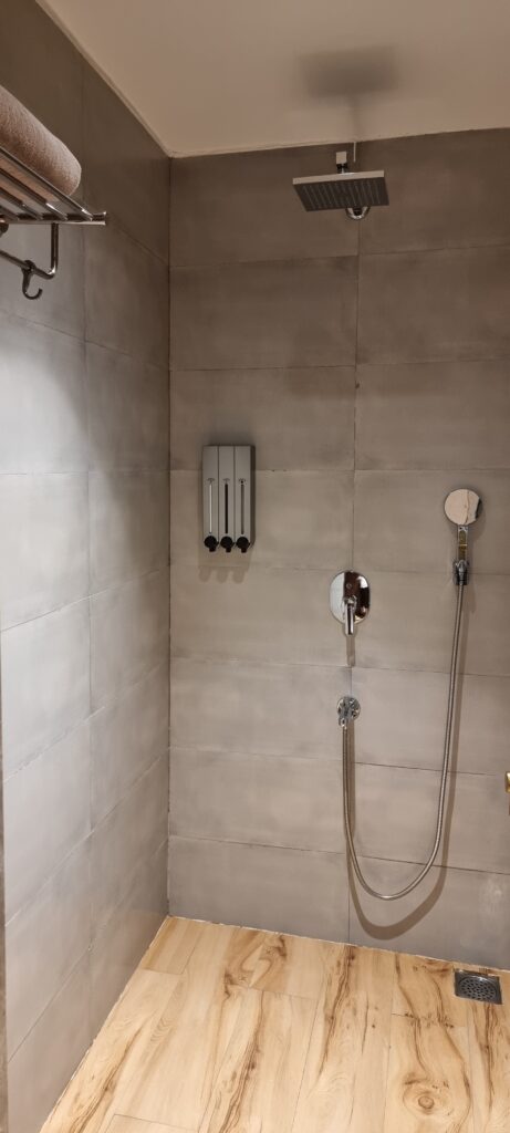a shower with a shower head and hose gym Encalm Privé lounge Delhi