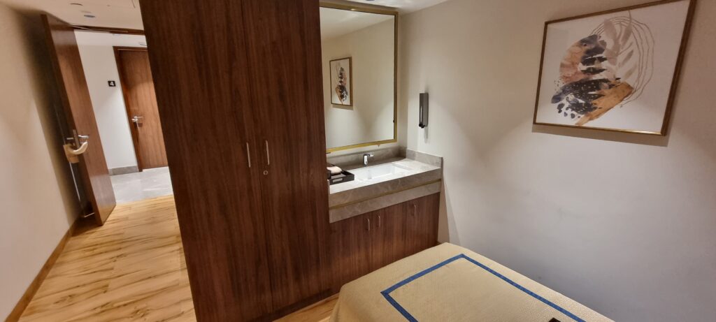 a bathroom with a mirror and a bed Encalm Privé lounge Delhi