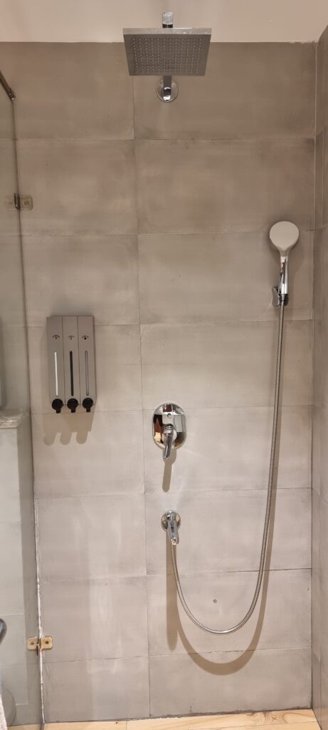 a shower with a shower head and faucet