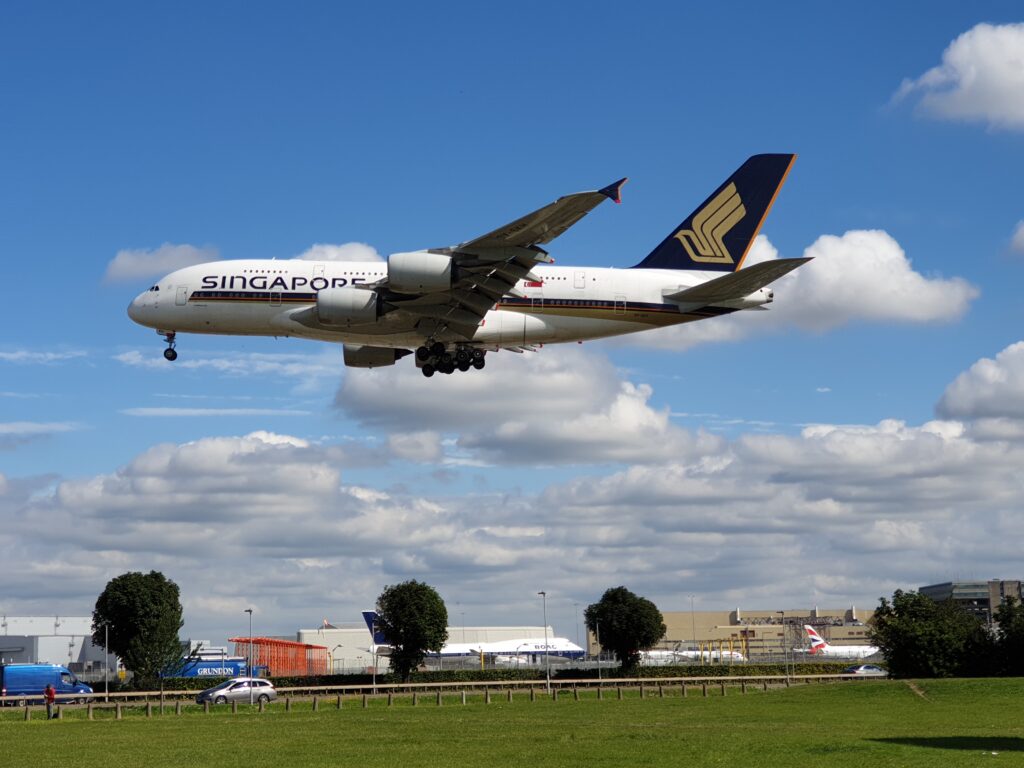 a large airplane flying in the sky Singapore Airlinens