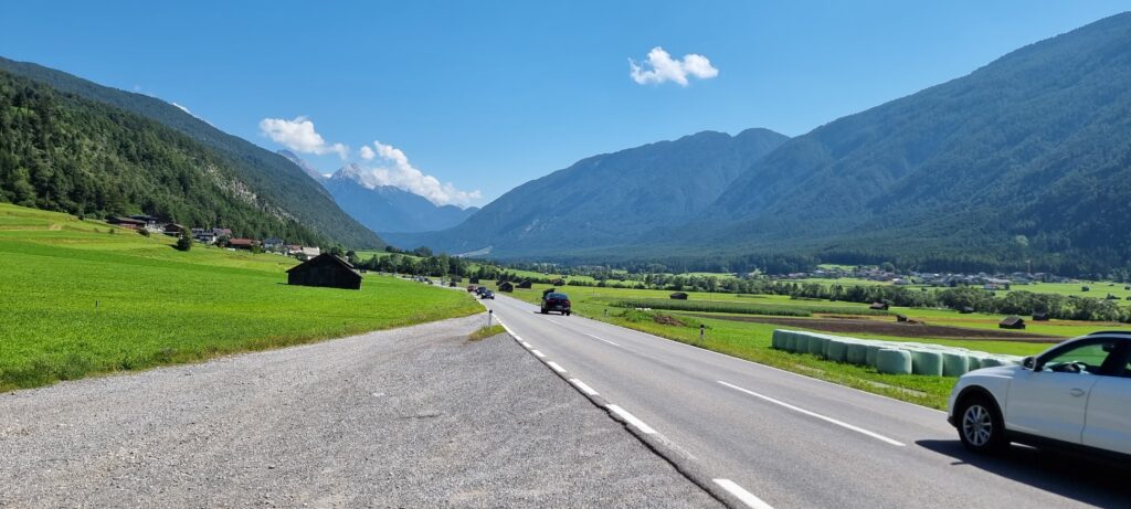 a road with cars on it and mountains in the background Austria missed flight connections