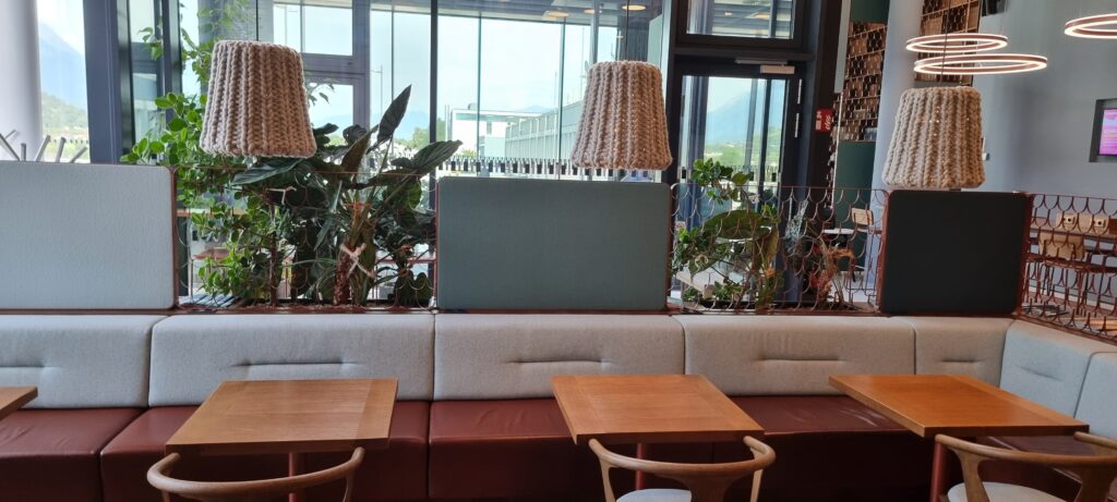 a table and chairs in a room with plants and a lamp