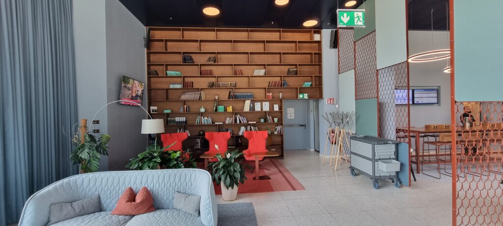 a room with a book shelf and chairs