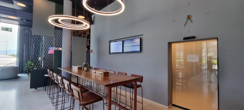 a long table with chairs and a television on the wall