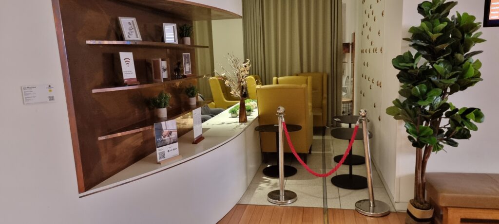 a room with a reception desk and chairs Review Plaza Premium Gatwick