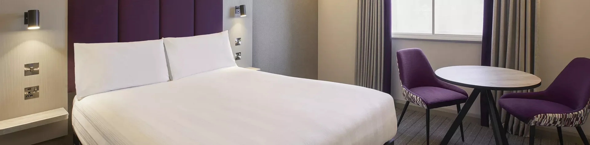 a bed with white sheets premier inn