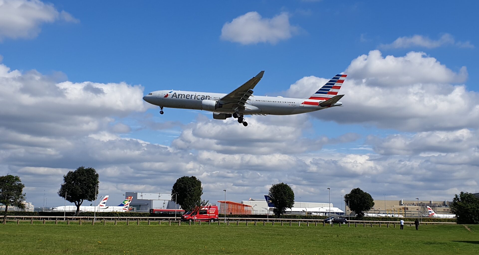 an airplane flying over a field American Airlines