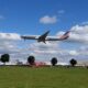 an airplane flying over a field American Airlines