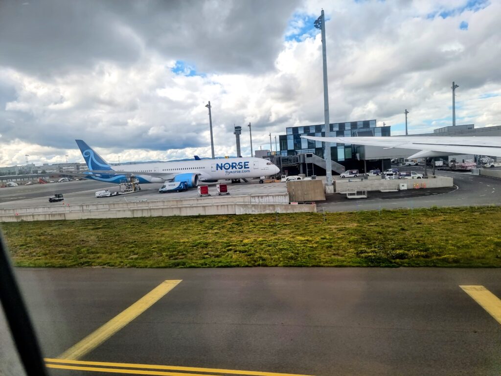 an airplane parked on a runway Norse Atlantic B789