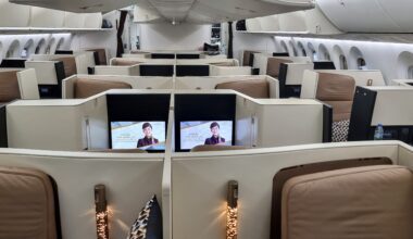 a row of chairs with monitors on the side booking tickets process airline Etihad