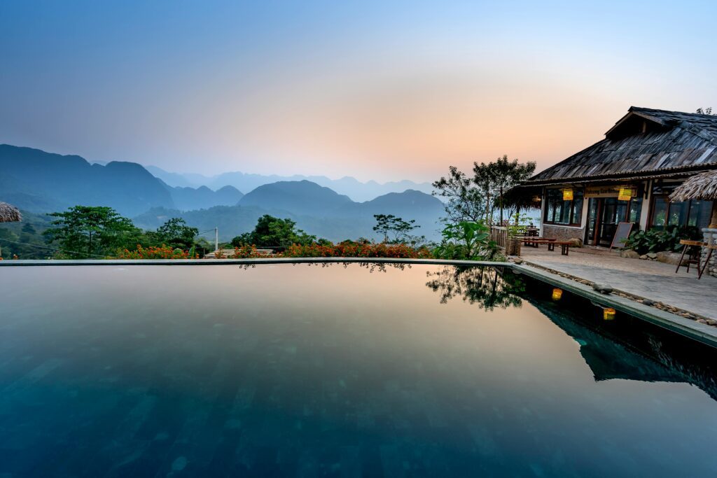 a pool with a building and mountains in the background Barclaycard avios plus