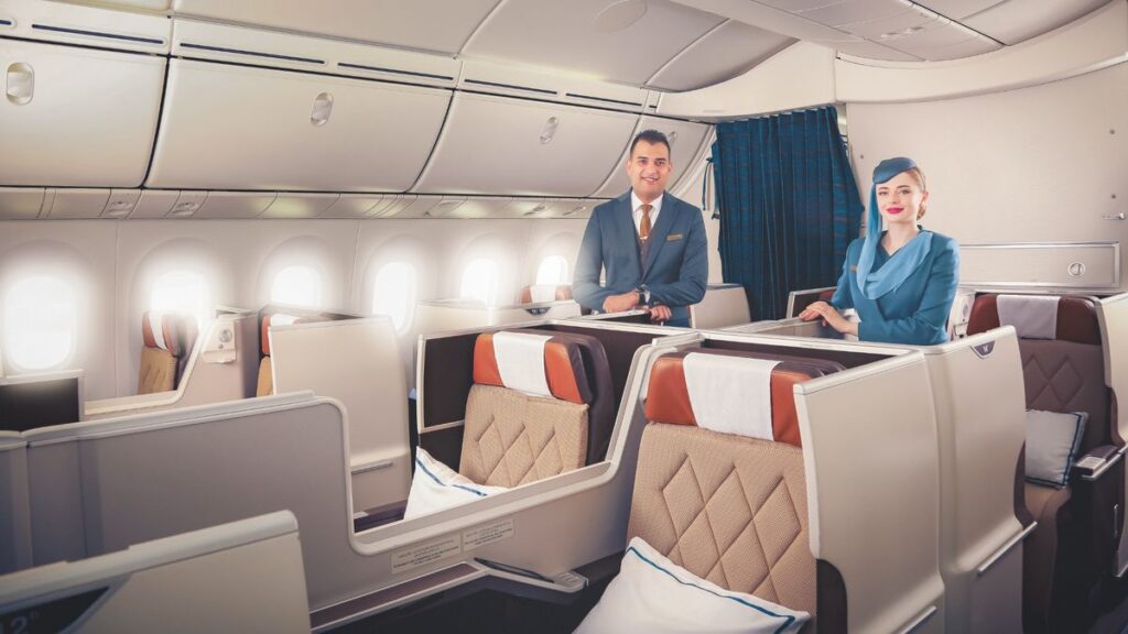 a man and woman in a plane Oman air