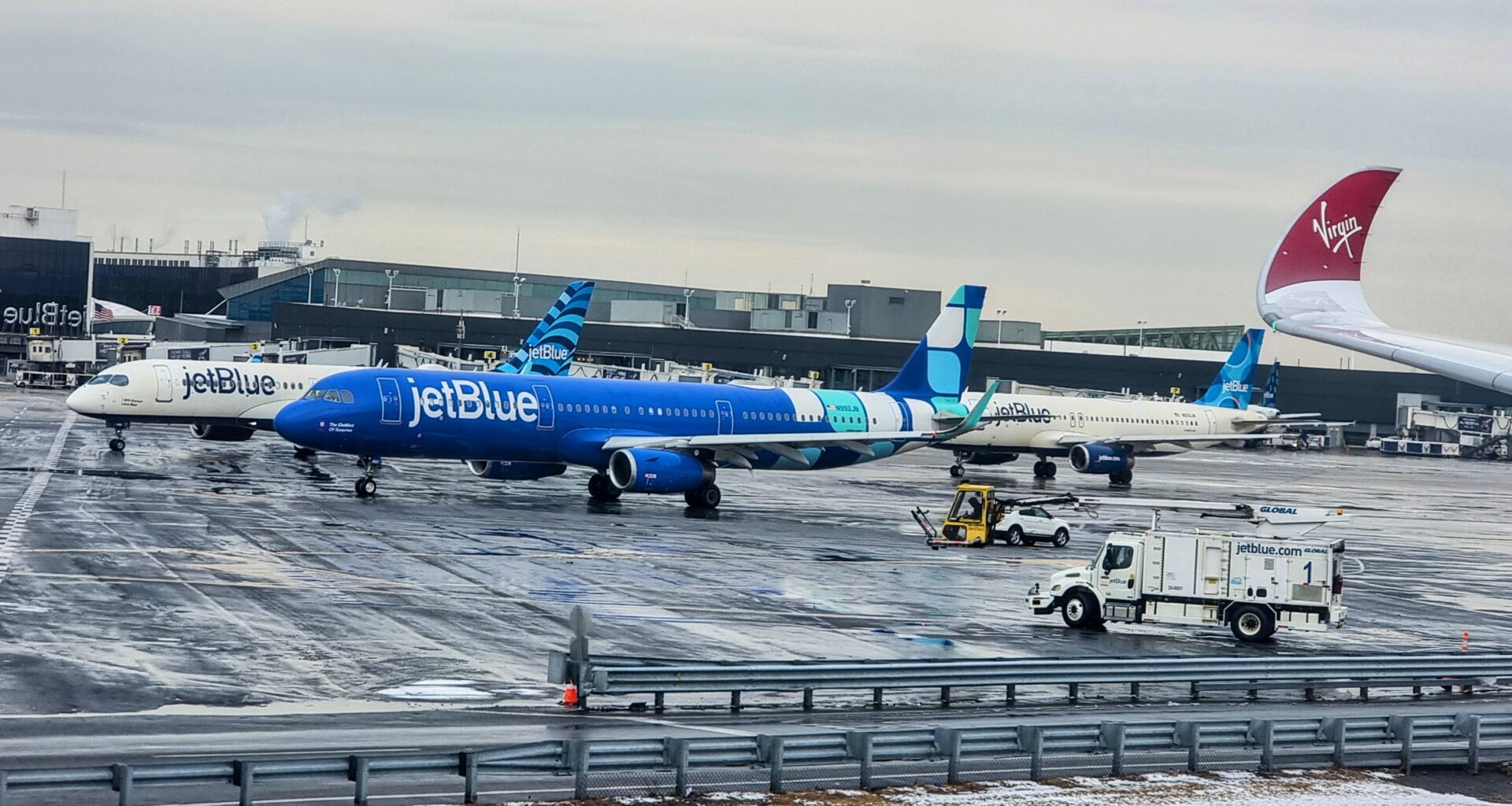 a blue and white jet planes on a wet runway vlogging pictures videos