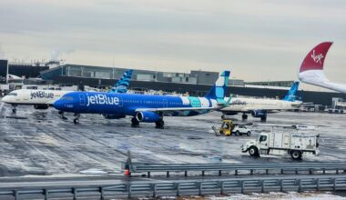 a blue and white jet planes on a wet runway vlogging pictures videos