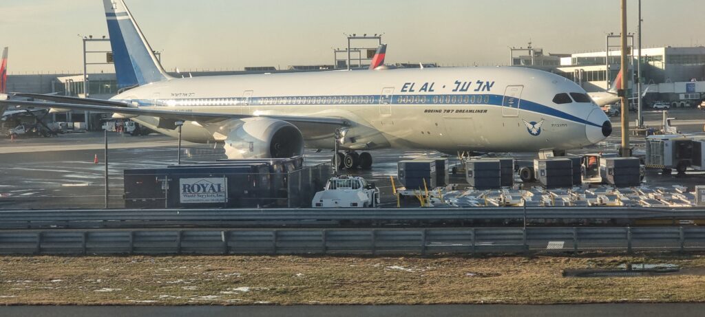 a large airplane at an airport ElAl dreamliner