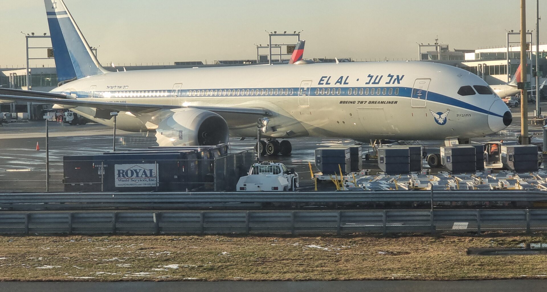 a large airplane at an airport ElAl dreamliner