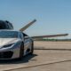 a silver sports car parked on a runway avis Hertz