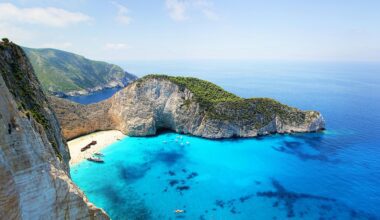 a beach with boats and blue water BA Freebird