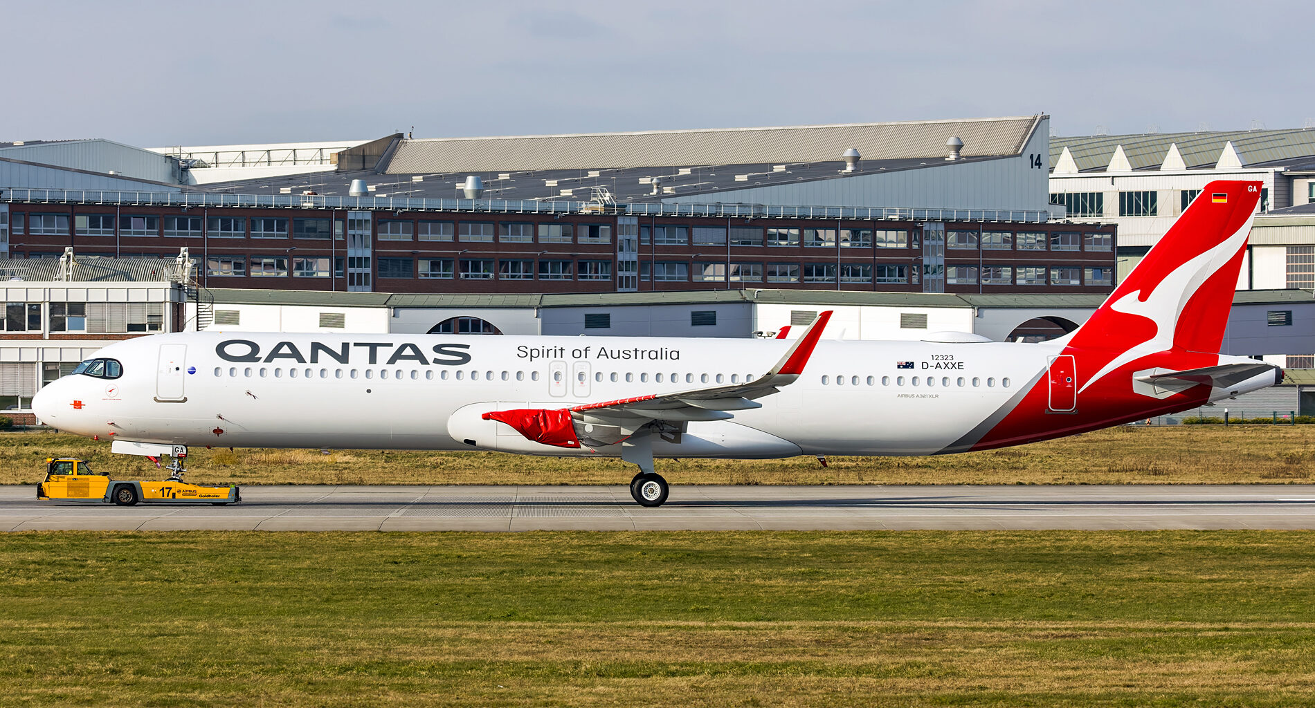 a large white and red airplane on a runway Qantas A321XLR