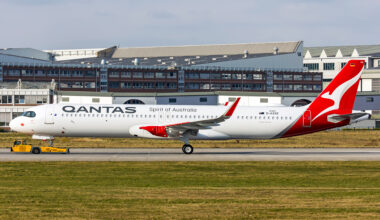 a large white and red airplane on a runway Qantas A321XLR