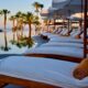 a pool with lounge chairs and umbrellas Barclaycard upgrade British Airways