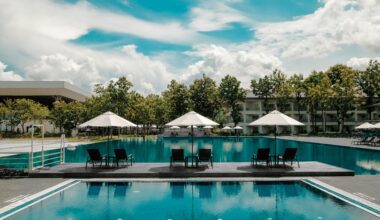 a pool with chairs and umbrellas Hilton Honors Plus Debit Card