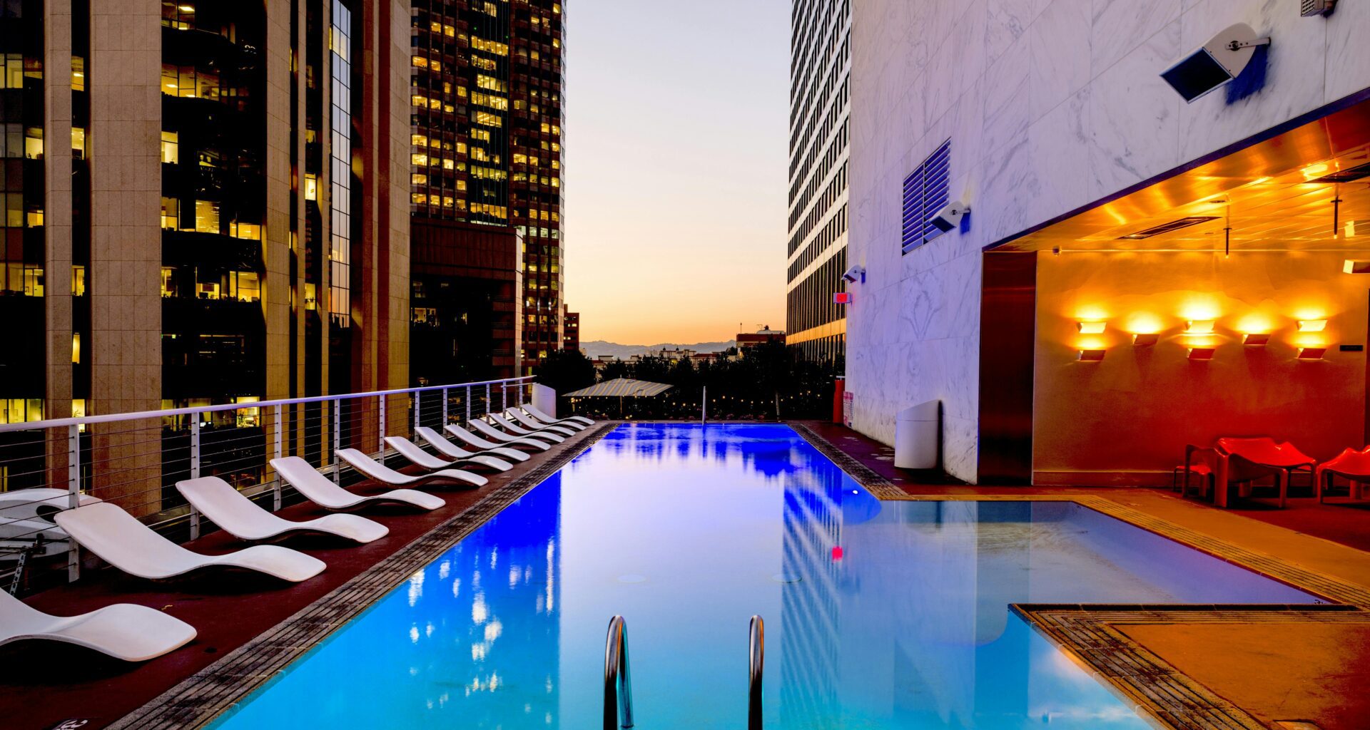 a pool with chairs around it American Express Preferred Rewards