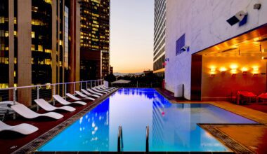 a pool with chairs around it American Express Preferred Rewards