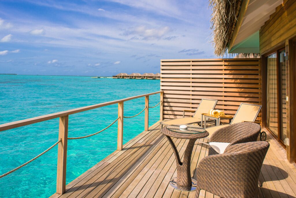 a deck with chairs and a table overlooking the ocean British Airways VS Virgin Atlantic