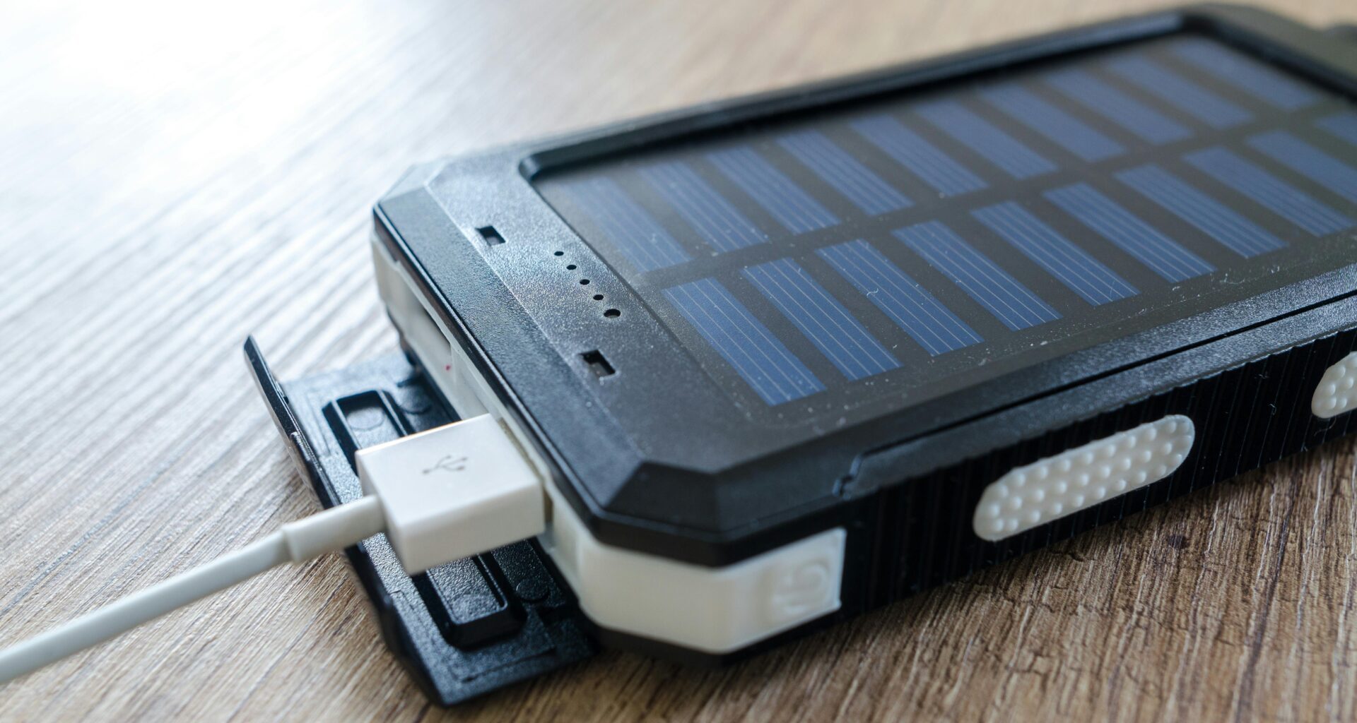 a solar cell phone with a white cable plugged into it Batteries power banks