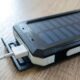 a solar cell phone with a white cable plugged into it Batteries power banks